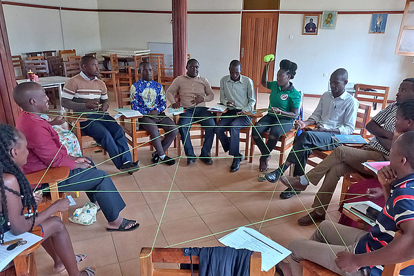 Im Team sind wir stärker. Die interaktive Übungen mit einem selbstgesponnenen Netz aus Wollfäden vermittelt den Teilnehmenden eines Jugendtrainings im August 2022 in Butende, wie wichtig Netzwerke für das Erreichen von Zielen sind.