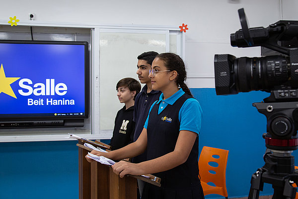 Vor laufender Kamera wird eine Modell-Debatte geführt, um das Kurzvideo als Lehrmaterial für Interessierte nutzen zu können. So soll die Kunst des Debattierens in Schulen verbreitet werden.