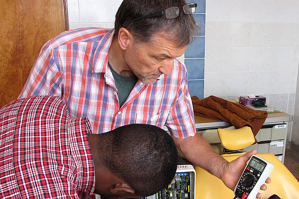 Frank Weithöner und sein tansanischer Kollege testen ein Gerät, bevor sie es zurück in den Operationssaal bringen.