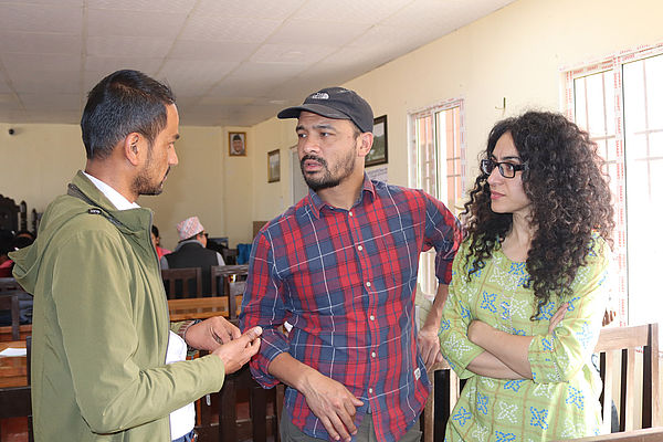 Hakimeh Yagootkar und Abishek Thapa sprechen mit dem Bildungsreferenten der ländlichen Gemeinde.