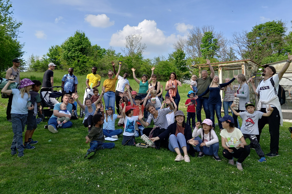 Gruppenfoto der zurückgekehrten AGIAMONDO-Fachkräfte und ihrer Familien auf der Wiese des Landhauses